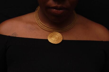 Détail de création artisanale en or végétal tressé Capim Dourado